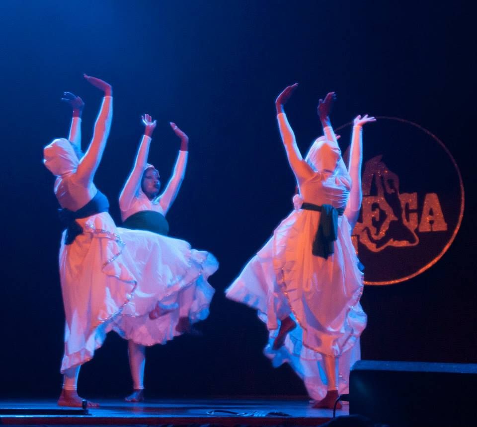 Dancers in white with arms raised