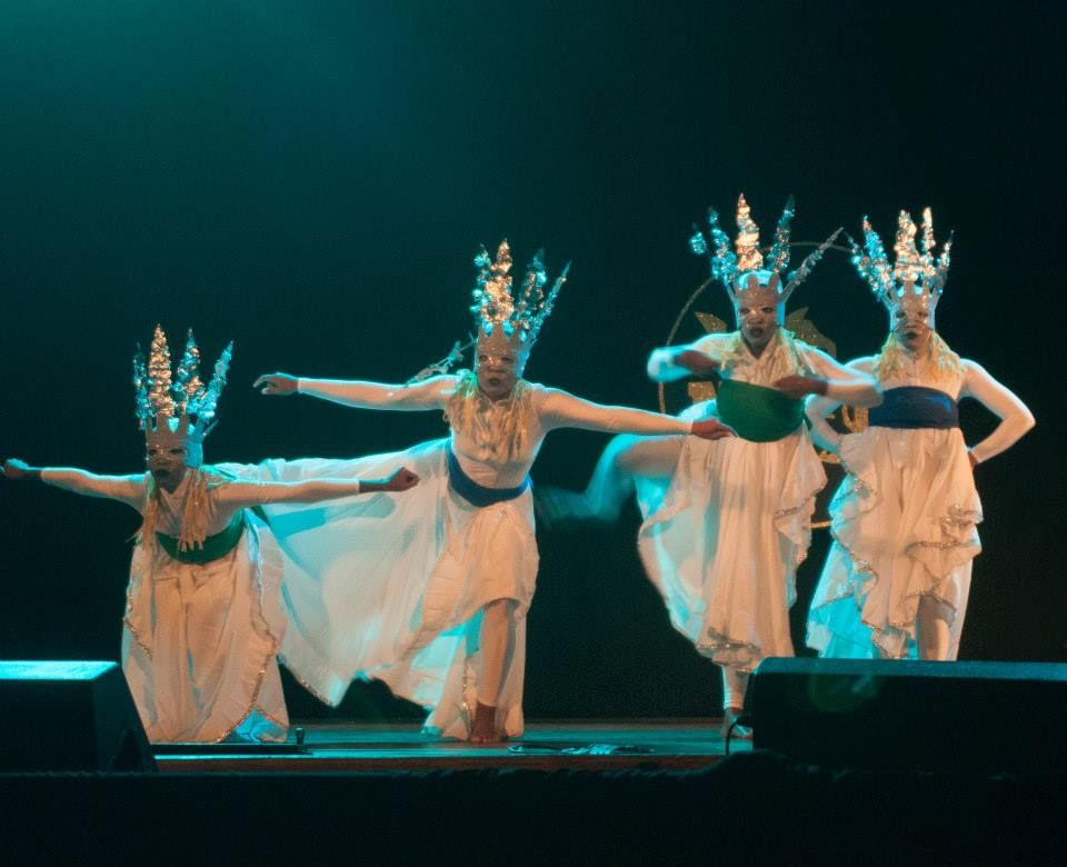 Four dancers in white wearing silver crowns
